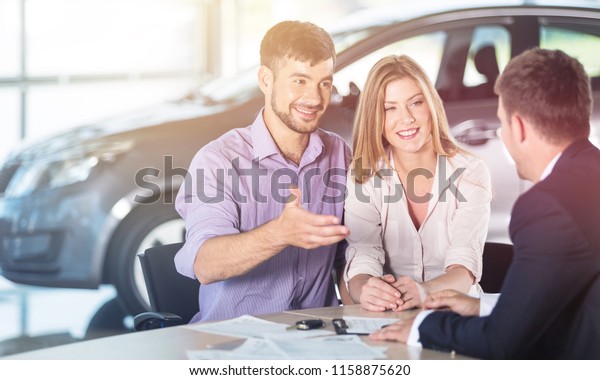 Happy couple with car
dealer