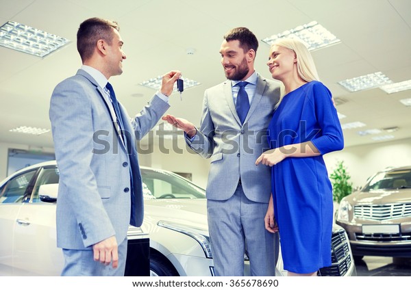 happy couple\
with car dealer in auto show or\
salon