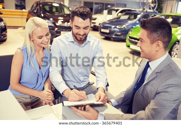happy couple
with car dealer in auto show or
salon
