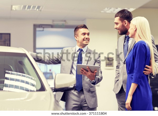 happy couple
with car dealer in auto show or
salon