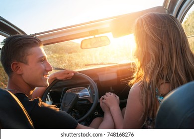 Happy couple in a car enjoying sunset. - Shutterstock ID 748168276
