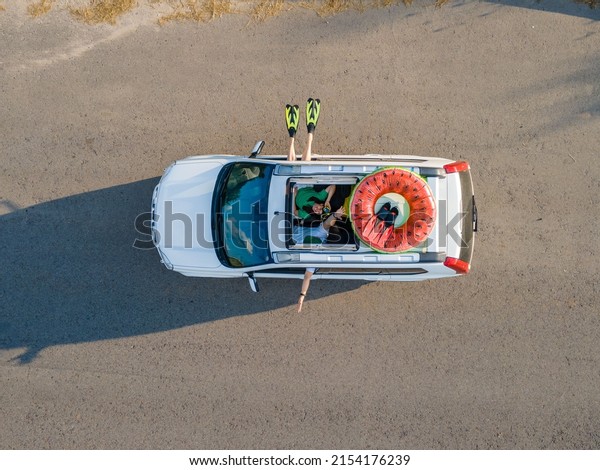 happy couple in car overhead view car travel to\
sea concept sunroof