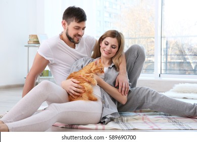 Happy Couple With Cat At Home