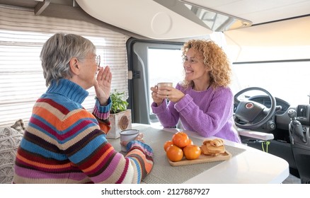 Happy Couple Of Caucasian Women Multigenerational Family Sitting Inside A Camper Van Motor Home Looking Enjoying A Coffee Break. Lifestyle And Travel Modern People, Vacation Journey Concept