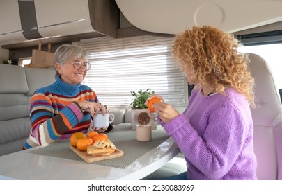 Happy Couple Of Caucasian Women Multigenerational Family Sitting Inside A Camper Van Motor Home Spending Time Together With Food And Drink. Lifestyle And Travel Modern People, Vacation Journey Concept