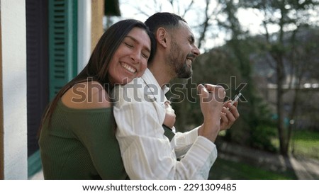 Happy couple celebrating success together. Girlfriend embraces elated boyfriend feeling triumphant. Successful man and woman showing support and happiness