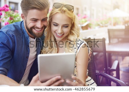 Happy couple checking menu at the tablet