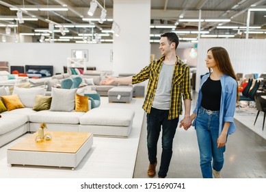 Happy couple choosing furniture in store