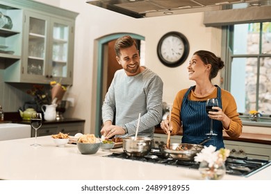 Happy, couple and cooking with love in kitchen for bonding with food, wine and conversation with ingredients. Man, woman and together in home for preparing meal with care, compassion and speaking. - Powered by Shutterstock