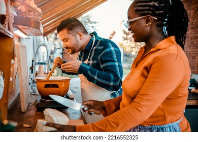 Happy Couple Cooking Together In Rustic Kitchen. Close Up Multiracial Friends Preparing Food