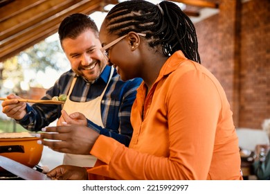 Happy Couple Cooking Together And Tasting Brussels Sprout, Close Up