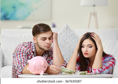 Happy Couple Counting Money From The Moneybox