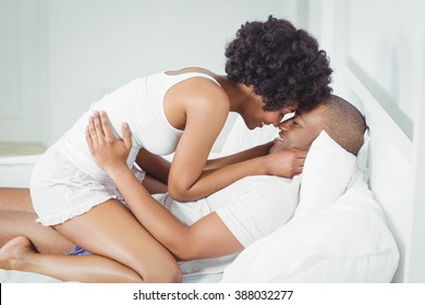 Happy Couple Cuddling On Bed At Home