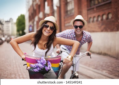 Happy couple cycling in the city
