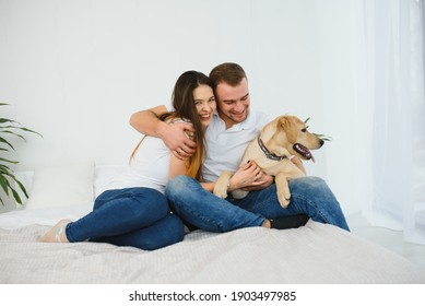 Happy Couple With Dog In Living Room