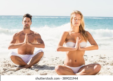 Happy couple doing yoga on the beach - Powered by Shutterstock