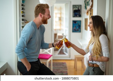 Happy Couple Drinking Beer And Toasting At Home