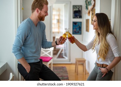 Happy Couple Drinking Beer And Toasting At Home