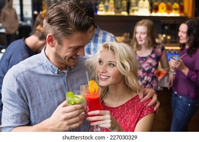 Happy Couple Drinking Cocktails Together At The Bar