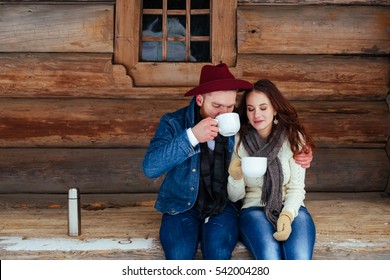 Happy Couple Drinking Tea And Wood Old House