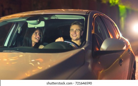 The Happy Couple Drive A Car. Evening Night Time