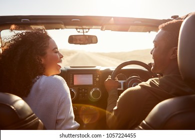 Happy couple drive looking at each other, rear passenger POV - Powered by Shutterstock