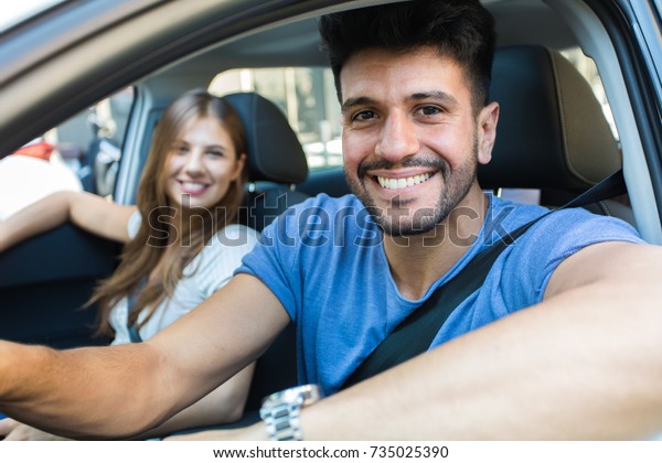 Happy couple driving in a\
car