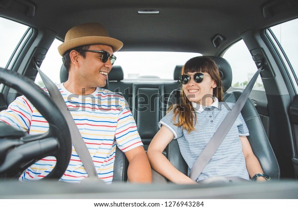 Happy\
couple driving in car. Enjoying travel\
concept.