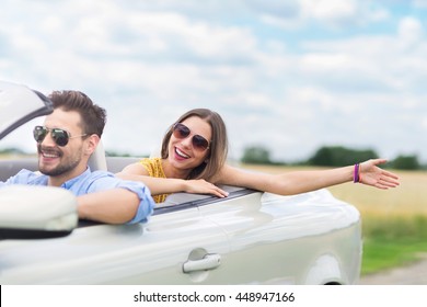 Happy Couple Driving In Convertible