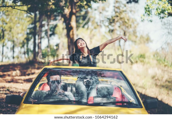 Happy Couple Driving in\
Convertible