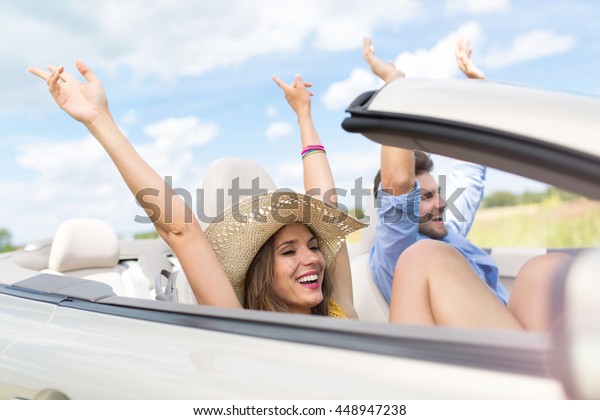Happy Couple Driving in\
Convertible