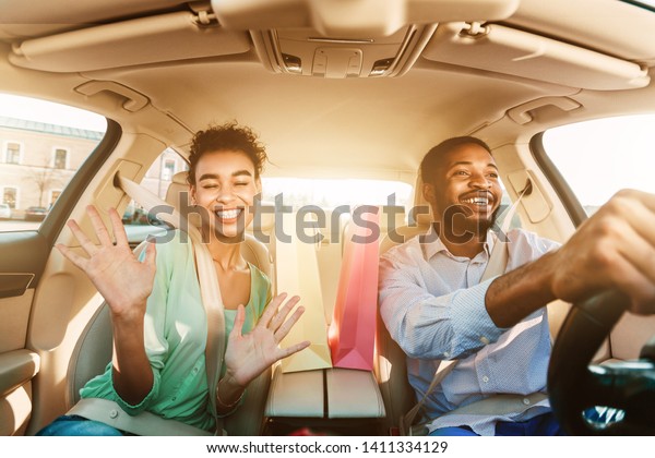 Happy Couple Driving Home After Shopping
In Mall, Listening Music And Singing In
Car