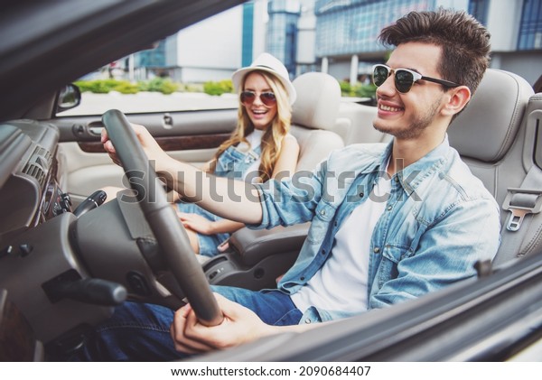 Happy couple\
driving on the cabriolet in the\
city.
