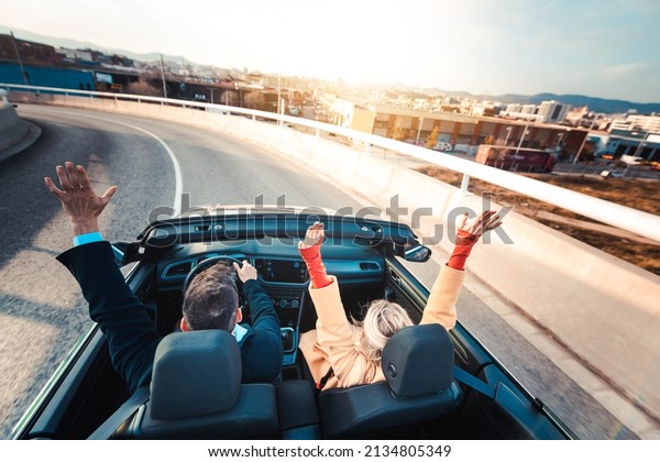 Happy couple driving on the road in\
convertible car - Friends rent cabrio auto on vacation - Roadtrip,\
freedom, travel and transport rental service\
concept	