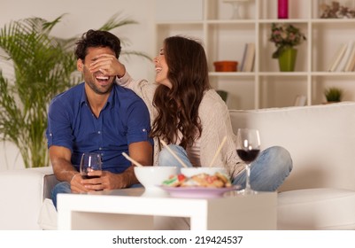 Happy Couple Eating Chinese Food And Drinking Wine At Home.