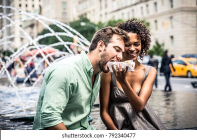 Happy couple eating hot dogs and having fun in New york city