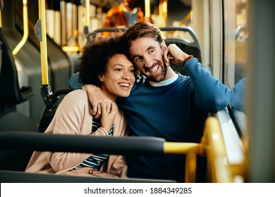 Happy Couple Embracing While Commuting By Bus And Looking Through The Widow.