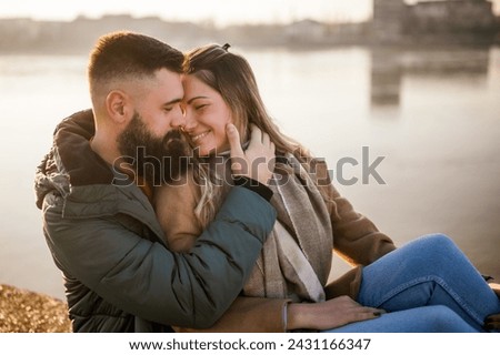 Happy couple embracing while  enjoy sitting by the river.