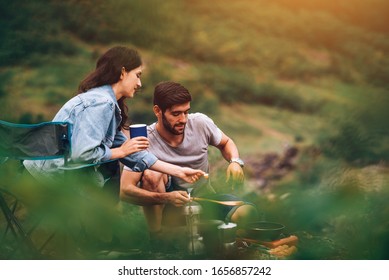 Happy Couple Enjoy Cooking in front of Camping Tent at Campsite in the Morning - Shutterstock ID 1656857242
