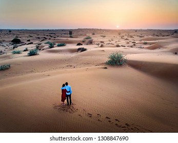 Happy couple enjoying desert sunset aerial view - Powered by Shutterstock