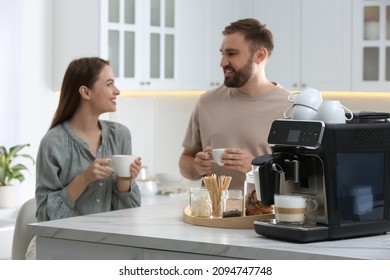 Happy couple enjoying fresh aromatic coffee in kitchen, focus on modern machine - Powered by Shutterstock