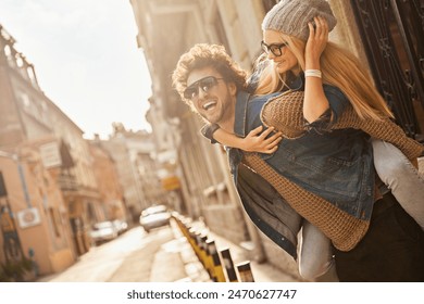 Happy couple enjoying a playful moment outdoors on city street - Powered by Shutterstock