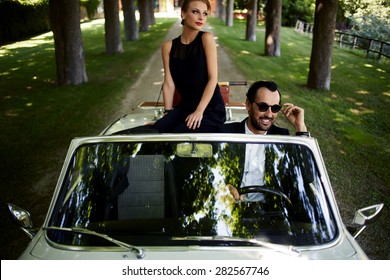 Happy Couple Enjoying A Ride On Their Luxury Convertible In The Summer,gorgeous Rich Woman Feels So Glad While They Riding On Cabriolet With Sure Handsome Brunette Man, Romantic Couple At Journey Trip 