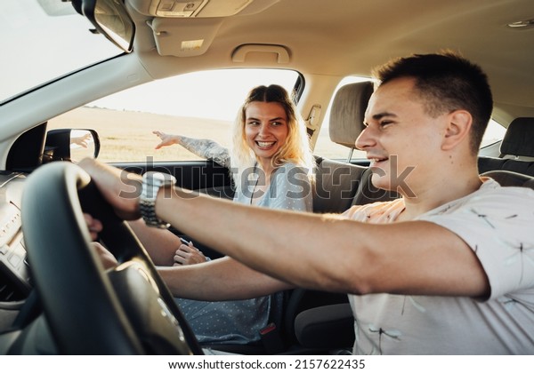 Happy Couple Enjoying Road Trip,\
Young Woman and Man Having Fun Time While Traveling by\
Car