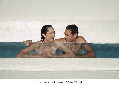 Happy Couple Enjoying In Swimming Pool At Resort