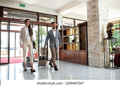 Happy couple entering the hotel pulling their luggage, vacation concept  - Powered by Shutterstock