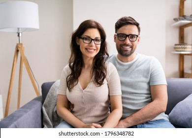 Happy Couple Family Wearing Eye Glasses On Couch