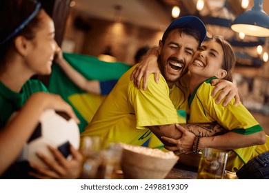 Happy couple of fans embracing while celebrating victory of their favorite sports team. - Powered by Shutterstock