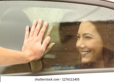 Happy Couple Or Friends Saying Good Bye Touching Hands Through A Car Window Before Travel