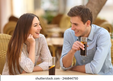 Happy Couple Or Friends Talking In A Restaurant And Looking Each Other